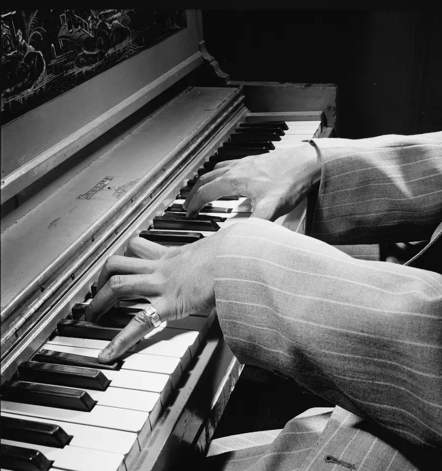 Nat King Cole's hands on a piano keyboard